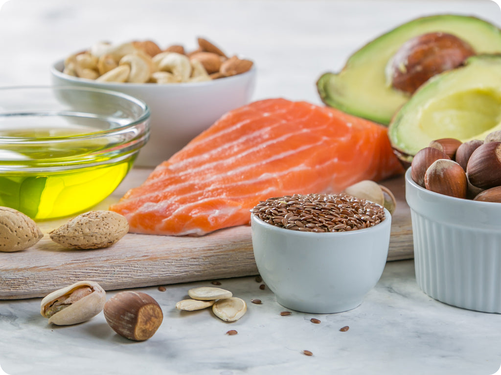 fresh wild salmon on a cutting board with fresh avocado and olive oil