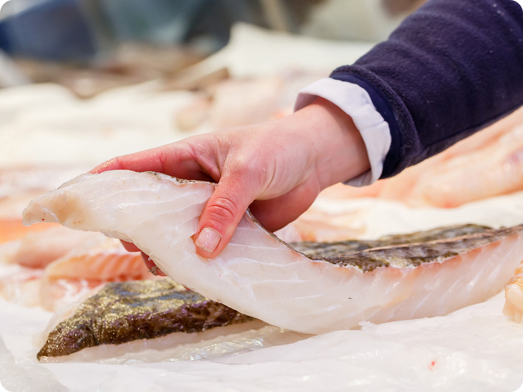 fresh fish on ice being inspected by quality control