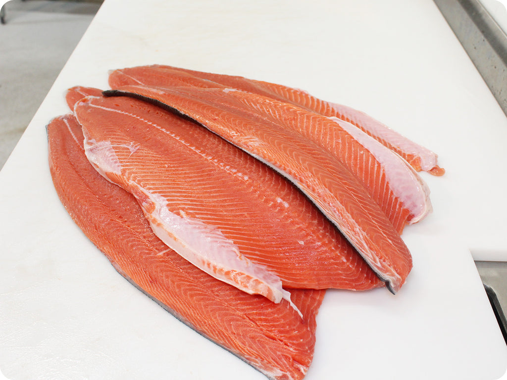 bright red fresh wild coho fillet on cutting board