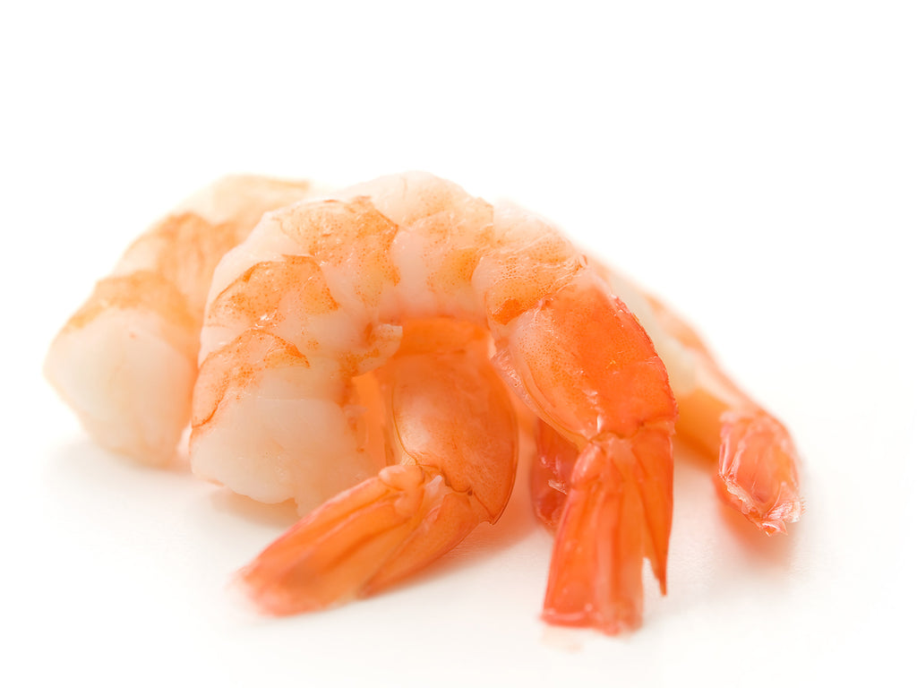 Plump, white shrimp with head and shell removed. The cooked Tiger Shrimp have a beautiful orange speckling when removed from their red shell.