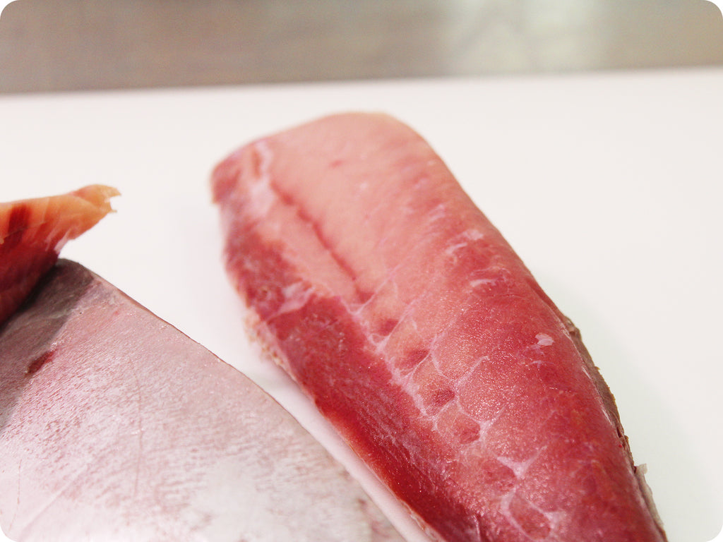 hamachi fillet on cutting board with knife