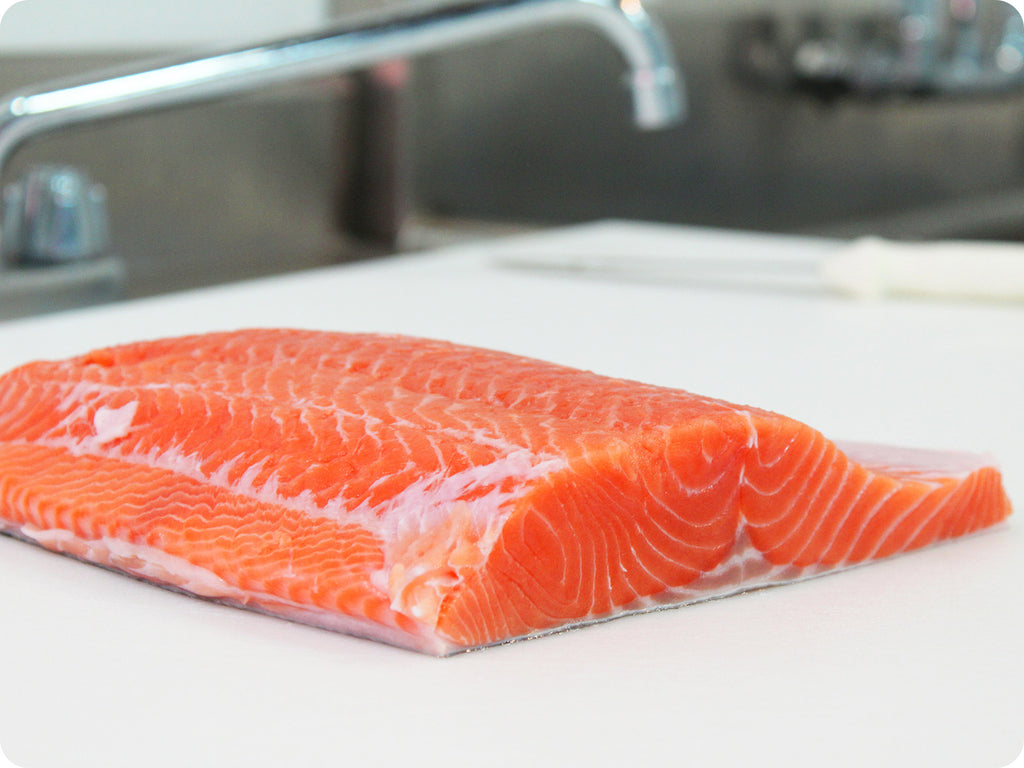 fresh wild king salmon fillet on cutting board